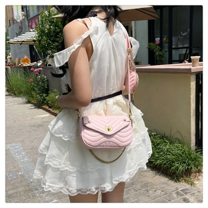 Detail of pink quilted crossbody bag with matching round mini pouch and woven strap