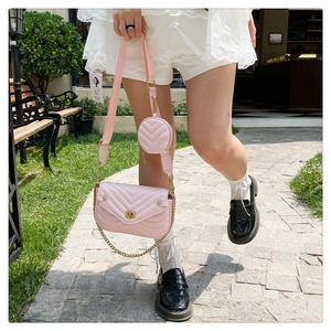 Close-up of pink quilted crossbody bag featuring gold hardware and a mini round pouch