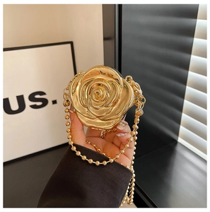 Détail d'un sac de soirée 3D en forme de rose dorée avec finition métallique et chaîne