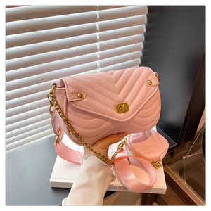 Pink quilted crossbody bag detail showing gold turn-lock and stylish wide fabric strap