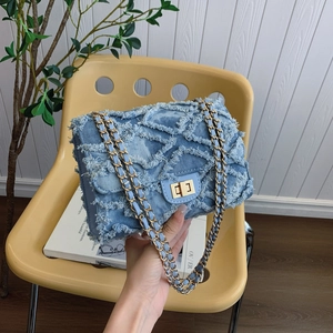 Quilted denim chain crossbody bag with frayed edges and gold-tone metal hardware