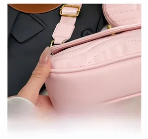 Detail of pink quilted handbag showing precision wavy stitching and golden metal buckle
