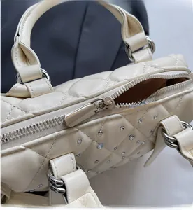 Detail of silver smooth zipper and sparkling rhinestones on quilted boston handbag