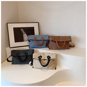 Detail view of four casual canvas handbags in blue, brown, grey, and beige with round handles
