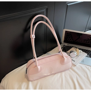 Close-up of pink leather handbag with heart-shaped detail in a modern lifestyle setting