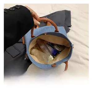 Detail view of large capacity blue denim tote showing interior storage and magnetic closure