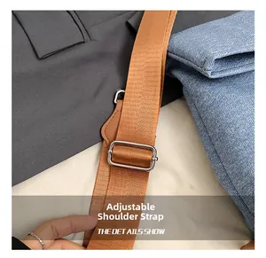 Detail of adjustable nylon shoulder strap with a polished metal slider on a tote bag