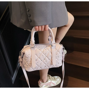 Detail of pink quilted Boston bag with shimmering rhinestones and silver hardware buckle