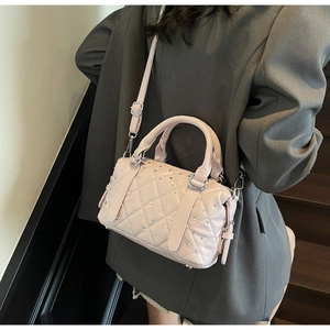 Pink quilted Boston bag with rhinestones shown styled on a model in a grey blazer