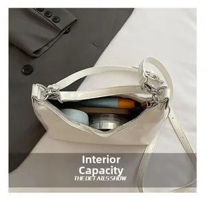 Vue intérieure montrant la capacité d'un sac demi-lune blanc en cuir verni brillant