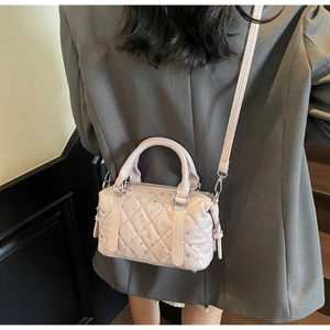 Detail of light pink quilted Boston bag with shimmering rhinestones and metal hardware