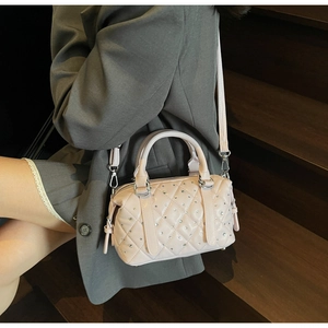 Detail of pink quilted Boston bag with sparkling rhinestones and metal strap hooks