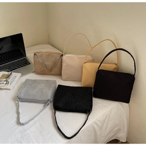 Collection of mini evening handbags in satin and rhinestone finishes on white bedding