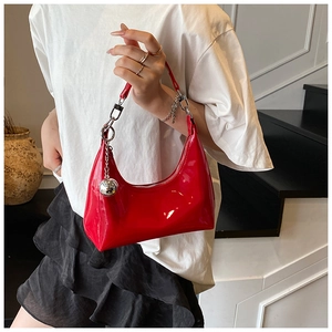 Détail du sac croissant en cuir verni rouge avec pendentif sphérique en métal argenté