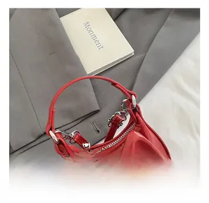 Detail der roten Handtasche mit Schleife, glänzendem Finish und Silber-Reißverschluss