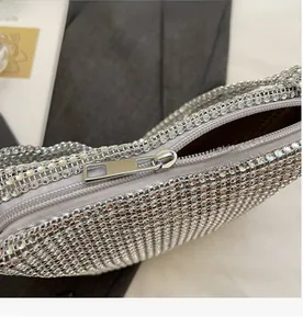 Detailed macro view of the smooth silver metal zipper on this rhinestone evening handbag