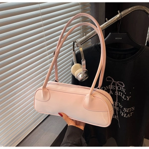 Pink minimalist cylindrical shoulder bag with adjustable long strap and matte finish