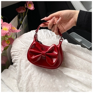 Detailansicht der roten Mini-Lacklederhandtasche mit Schleife und glänzender Textur