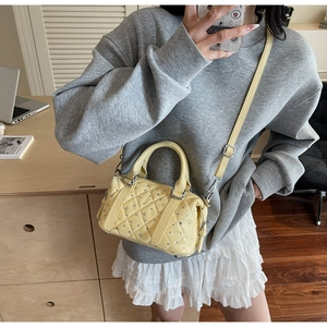 Detail of yellow quilted Boston bag with miniature rhinestones and silver hardware