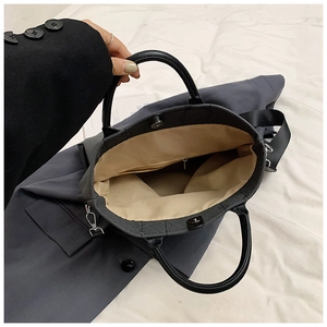 Detail of the black canvas bag interior showing the beige lining and zipper pocket