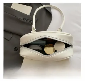 Top view of cream-white leather bowling bag interior showing spacious storage and dual zippers
