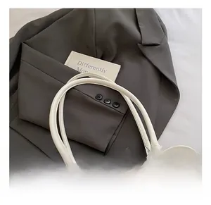 Detail shot of the comfortable white leather handle on a minimalist bowling handbag
