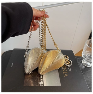 Detail von gold- und silberfarbenen Abendtaschen in Muschelform mit strahlenförmiger Textur