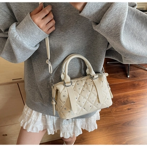 Close-up of cream quilted Boston bag with sparkling rhinestone detail and silver hardware