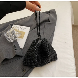 Close-up of a stylish black triangular handbag with shimmering rhinestones in a modern setting