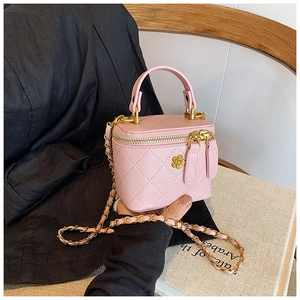 Pink quilted mini vanity bag detail featuring gold camellia hardware and chain strap