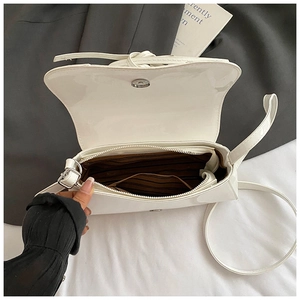 Detailed interior view of white glossy shoulder bag with brown striped lining and zipper pocket