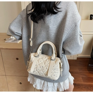 Rear view of cream quilted Boston bag with sparkling rhinestones and adjustable strap