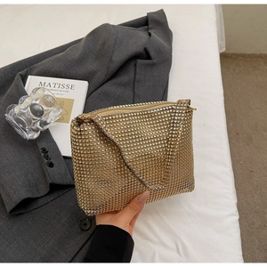 Detailed view of luxury gold rhinestone evening bag with sparkling hand strap in lifestyle set