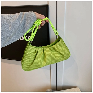 Close-up of neon green woven handbag featuring a unique pleated texture and thick rope handle