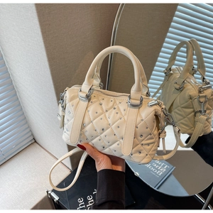 Detail of a beige quilted Boston bag with silver rhinestones and adjustable strap