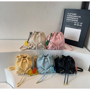 Detail of five colorful drawstring bucket bags featuring elephant charms and rivet base