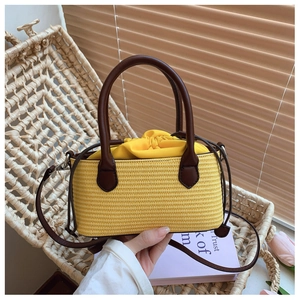 Yellow woven straw tote bag with brown leather handles and drawstring lining