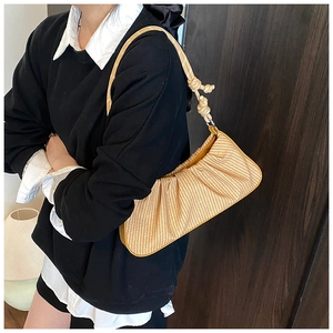 Detail of light brown woven shoulder bag with chic ruched texture and knot strap detail