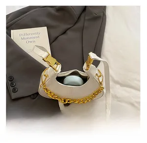 Macro view of white patent leather mini bag interior with gold chain and strap