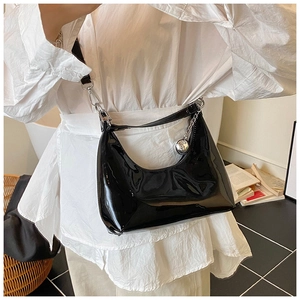 Détail du sac croissant en cuir verni noir avec chaîne argentée et breloque sphère