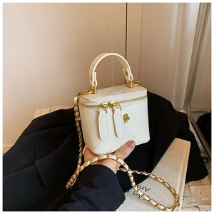 Detail of white quilted leather mini bag with gold chain strap and petal hardware