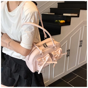 Close-up of pink Boston bag showing detailed stitching and cute bow-knot front pockets