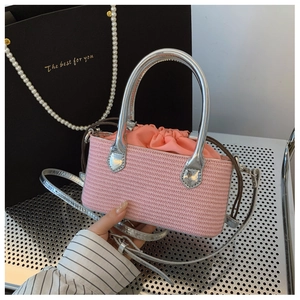 Close-up of pink woven straw bag with silver metallic handles and a drawstring pouch