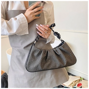 Detail of woven cloud bag with pleated black and white texture and knot handle