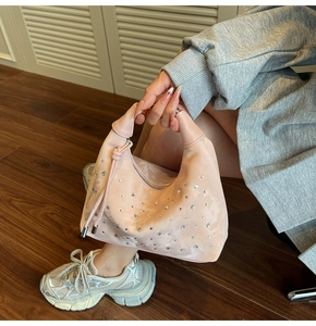 Detailed shot of pink satin hobo bag featuring sparkling rhinestones and a knotted handle