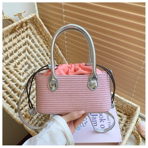 Detail of pink straw woven mini bag with silver metal handle and drawstring lining