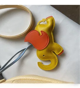 Detail of elephant-shaped leather bag charm with yellow finish and contrast stitching