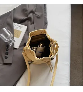 Detail shot of the spacious interior of a light yellow bucket bag with inner pocket