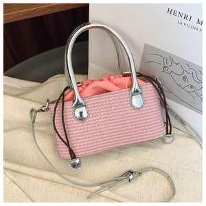 Detail of pink woven straw handbag with silver metallic handles and drawstring closure