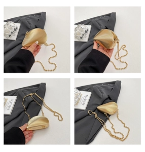 Detail einer goldenen Muschel-Abendtasche mit Vintage-Perlenkette und strukturierter Optik